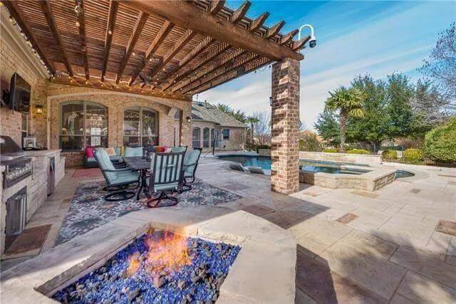 Rear patio with a trellis porch, a fire pit seating, and a swimming pool.
