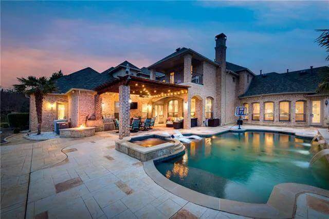 Rear view showcasing the covered patio and swimming pool with a spa.
