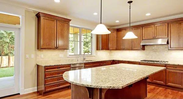 Kitchen with a center island and wooden cabinets that blend in with the hardwood flooring.