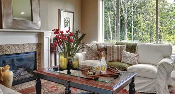 Family room with a skirted sofa and a fireplace topped by a mirror.