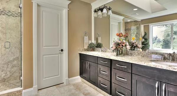 Primary bathroom with a dual sink vanity topped by a large mirror.