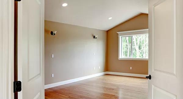 Primary bedroom with a vaulted ceiling and brown walls.