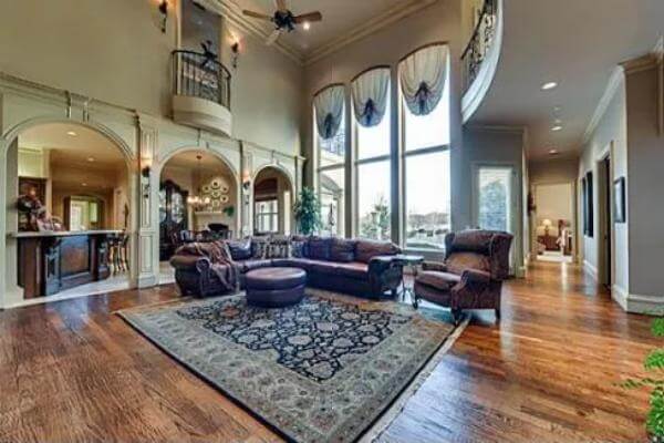 Family room with an L-shaped sofa, a wingback chair, and a round ottoman over the vintage area rug.