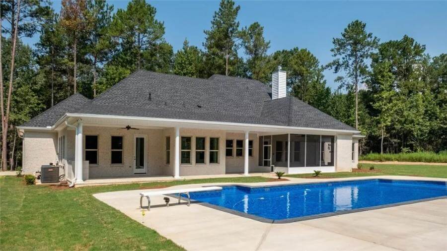 Rear view with covered and screened porches, a chimney, and a swimming pool.