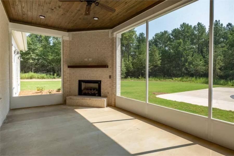 Covered porch with a wood-paneled ceiling and a corner fireplace.