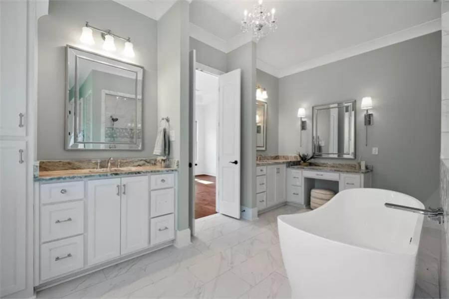 Primary bathroom with his and her vanities, a makeup counter, and a soaking tub.