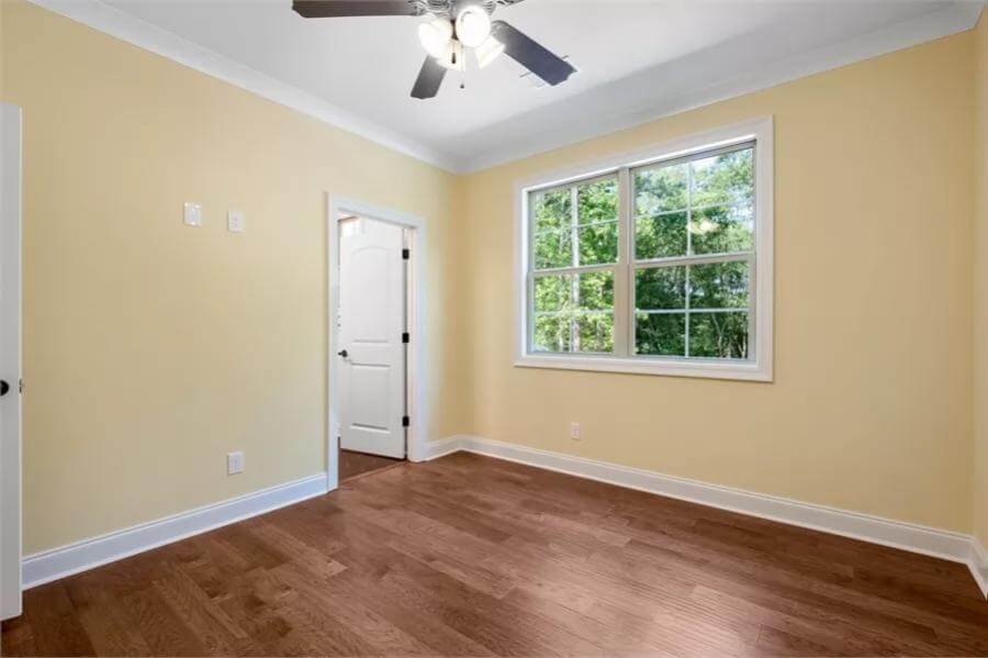 Bedroom with yellow walls and a hardwood floor.