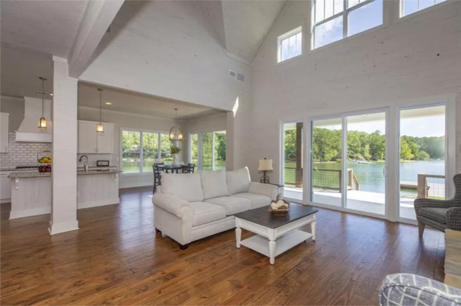 Living room with a sectional sofa, a tall vaulted ceiling, and sliding glass doors that open to a covered porch.