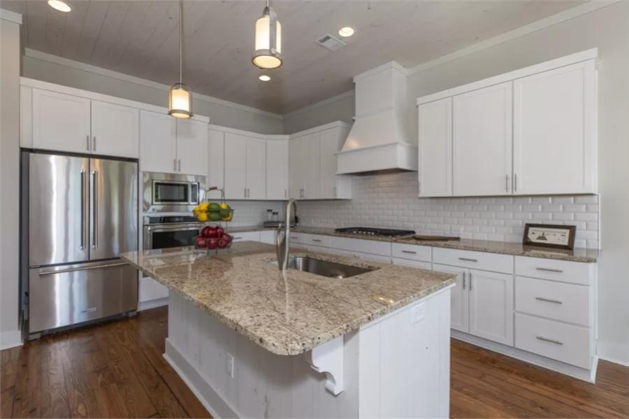 Kitchen with white cabinetry and a center island with a prep sink.
