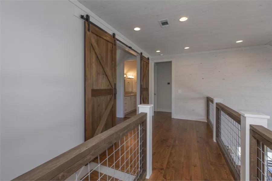Balcony with net railings and a hardwood floor.