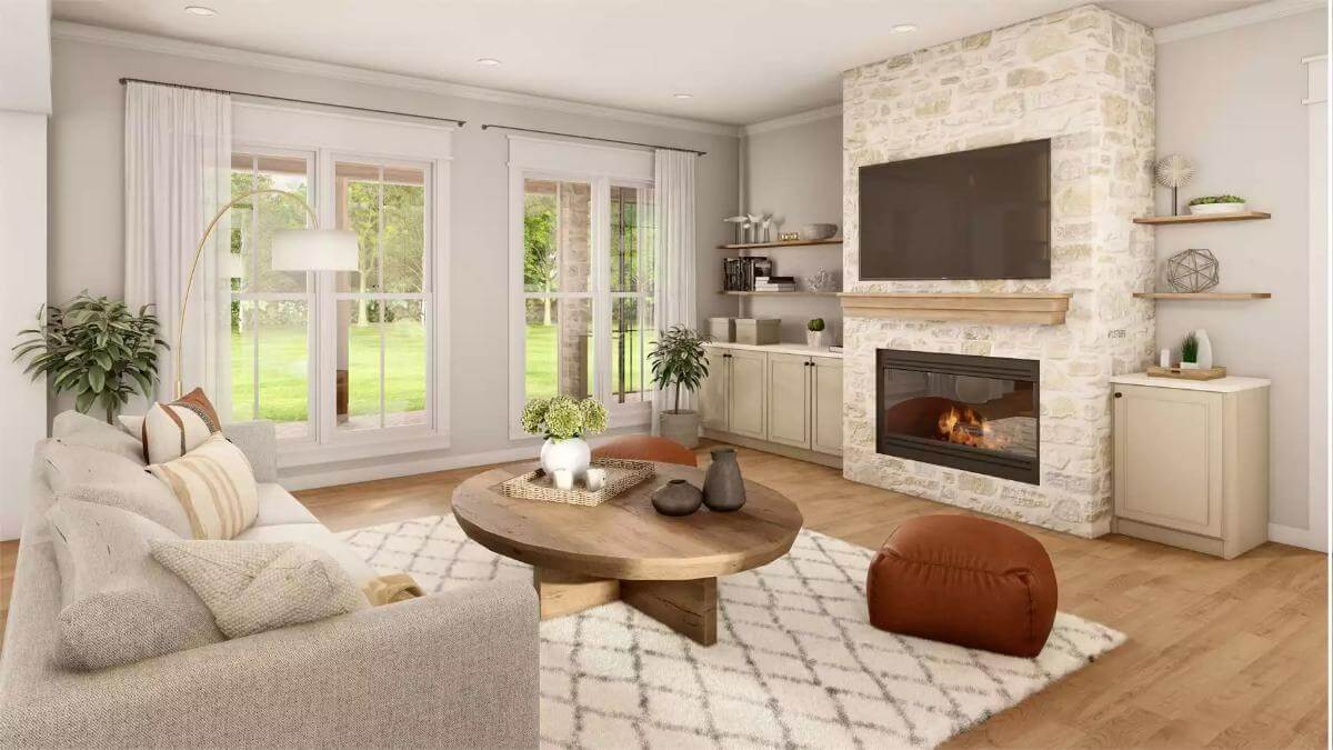 Great room with a sectional sofa, a round coffee table, and a stone fireplace topped by a TV.