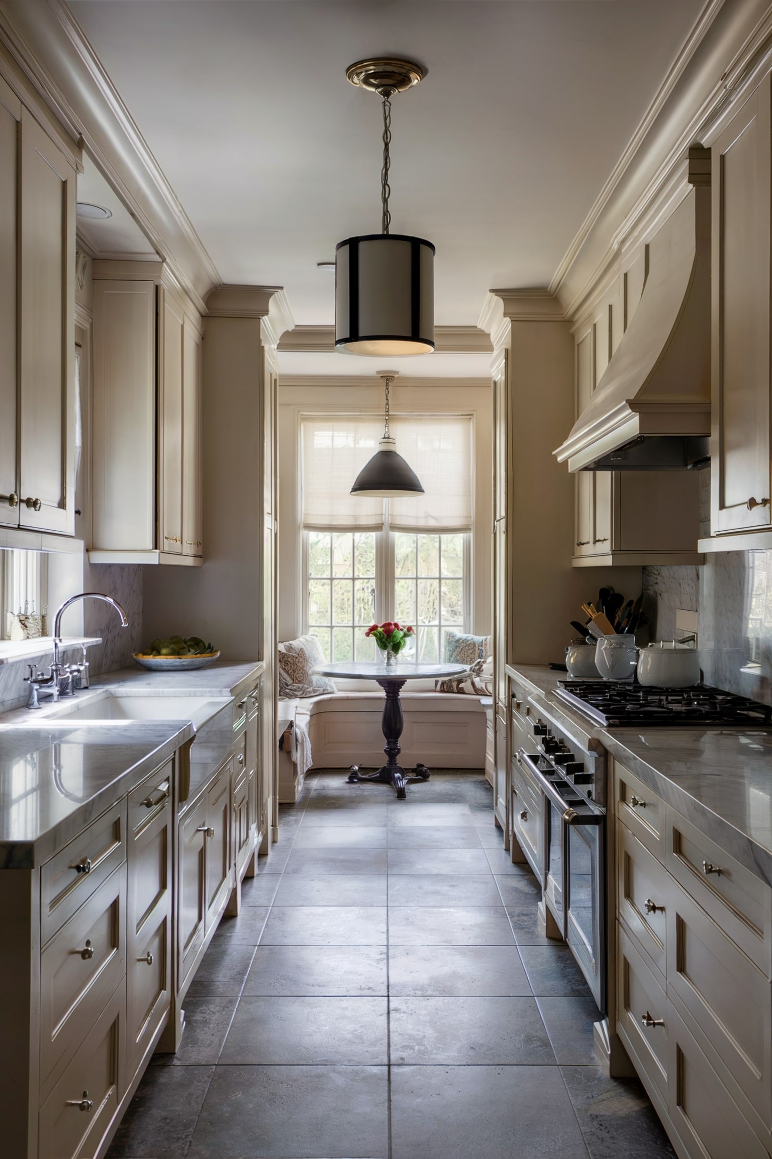 Galley kitchen with a breakfast nook at the end, featuring a bench and black table