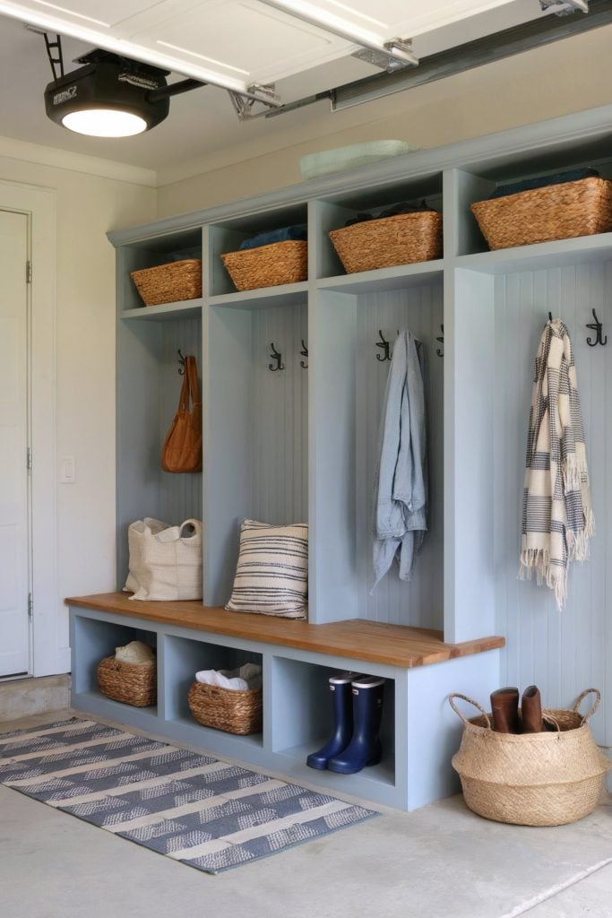 Blue built-in mudroom lockers with a bench, hooks, and baskets for storage