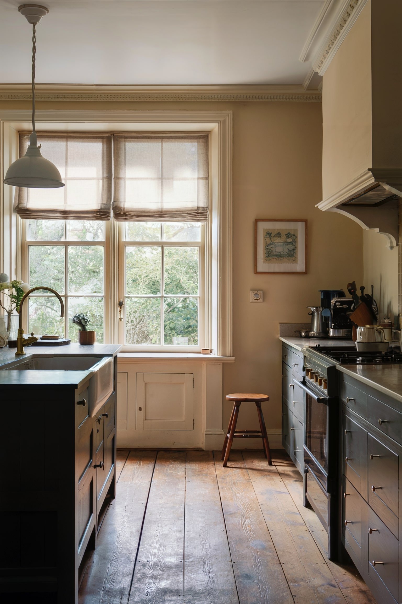 Rustic kitchen with neutral Roman shades and wooden floors