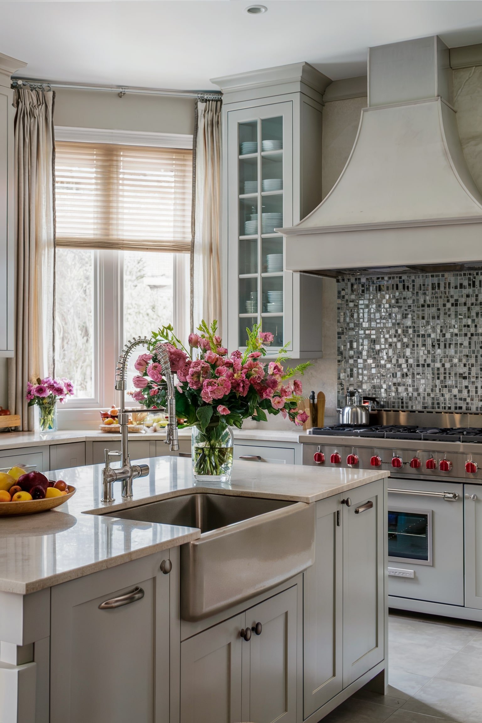 Bright kitchen with sheer drapes, farmhouse sink, and pink flowers on the counter