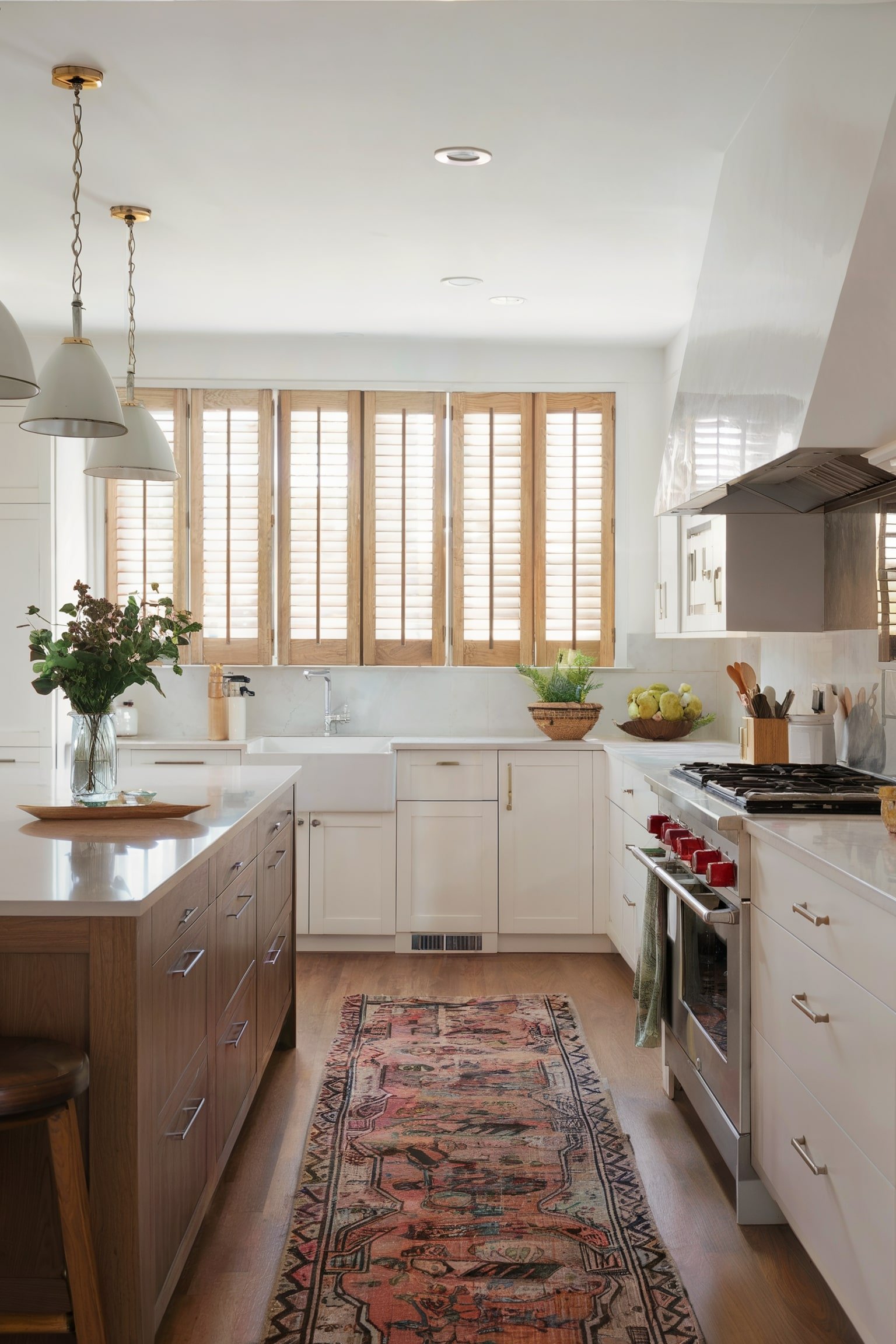 Bright kitchen with wooden shutters and a patterned runner rug