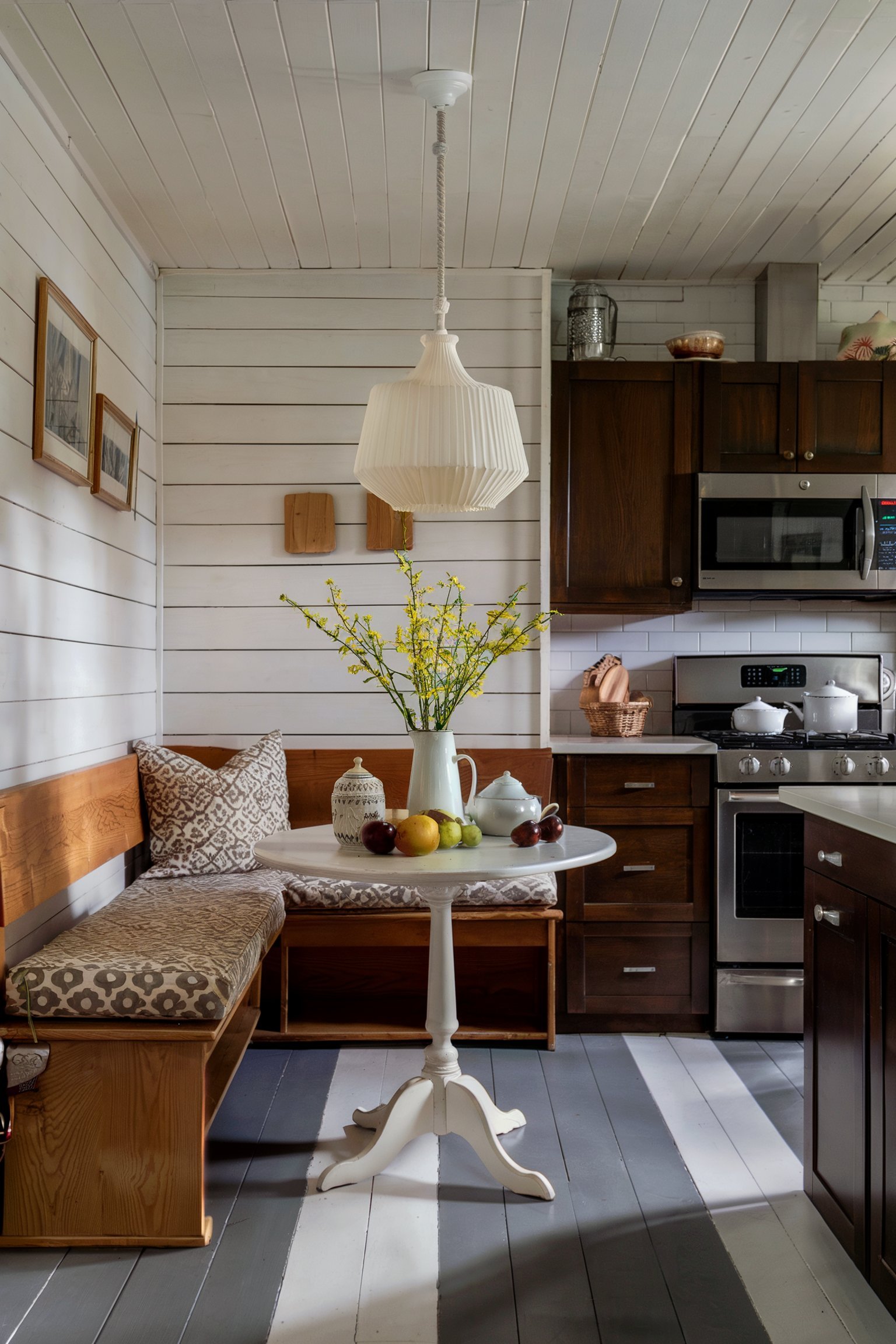 Cozy farmhouse kitchen with a wooden banquette bench and a small round table
