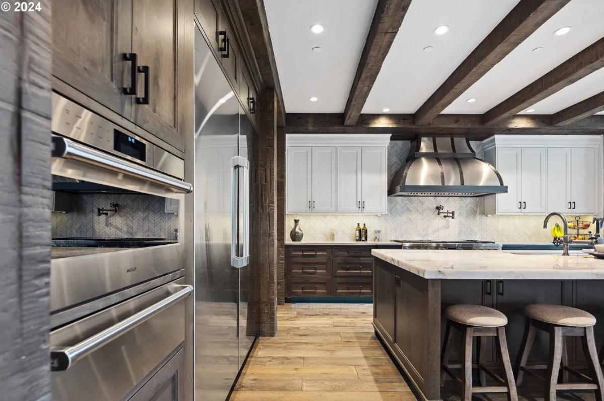 Kitchen with custom cabinetry, a counter breakfast bar and stainless-steel appliances.