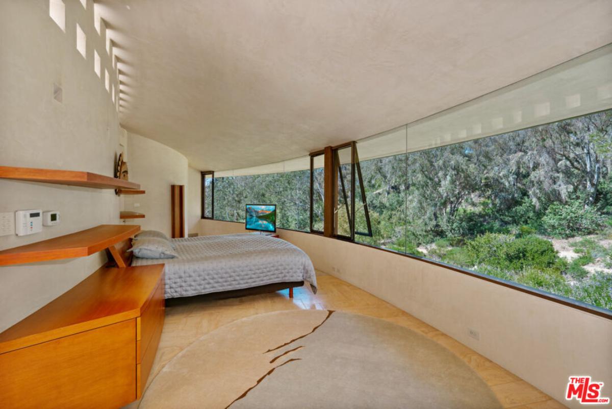 Bedroom with a large bed and glass walls.