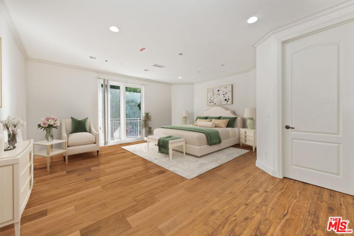 Bedroom with hardwood flooring and a large bed.
