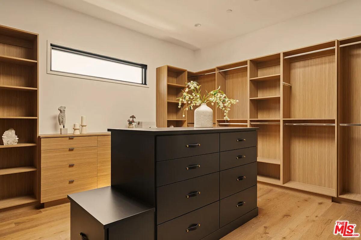 Walk-in closet with shelves and drawers.