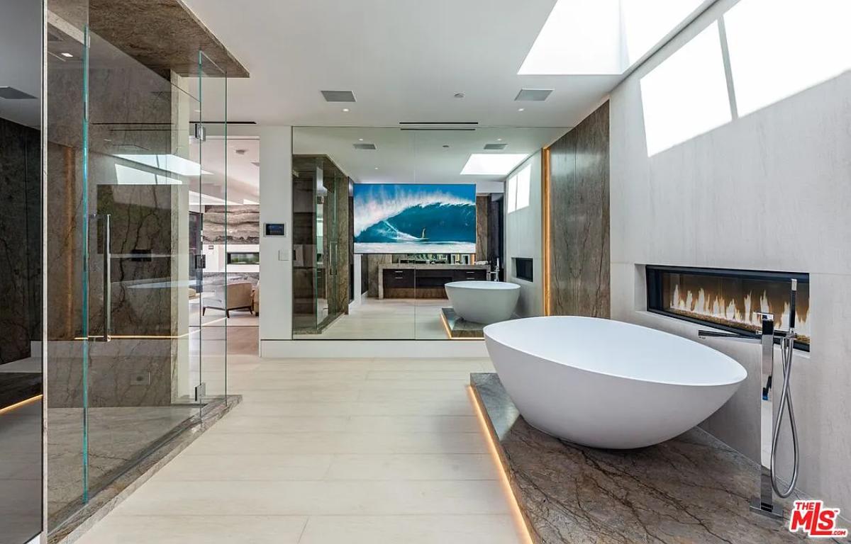 Bathroom with a soaking tub, walk-in shower and a fireplace.