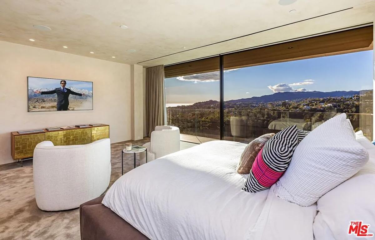 Bedroom with large sliding glass doors and carpet flooring.
