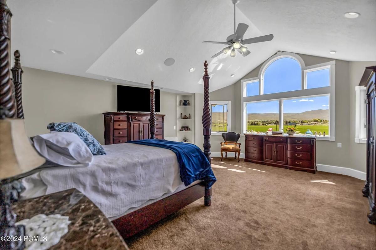 Bedroom with a large bed and carpet flooring.