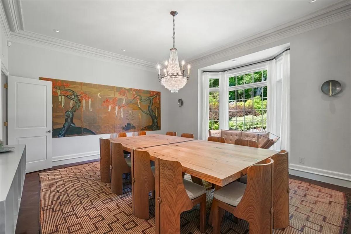 Dining room with a hardwood table and a chandelier.