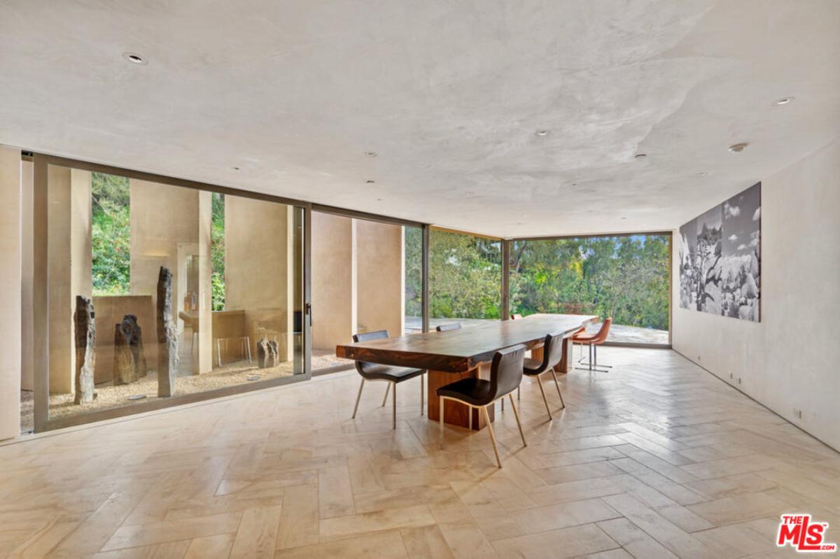 Dining room with a large wood table and glass walls.