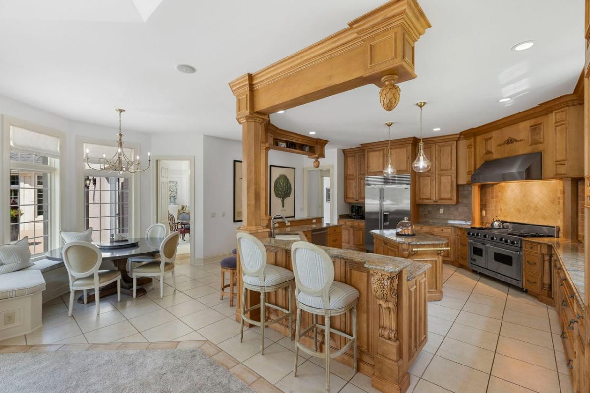 Kitchen with custom cabinetry, a counter breakfast bar and a center island prep area.