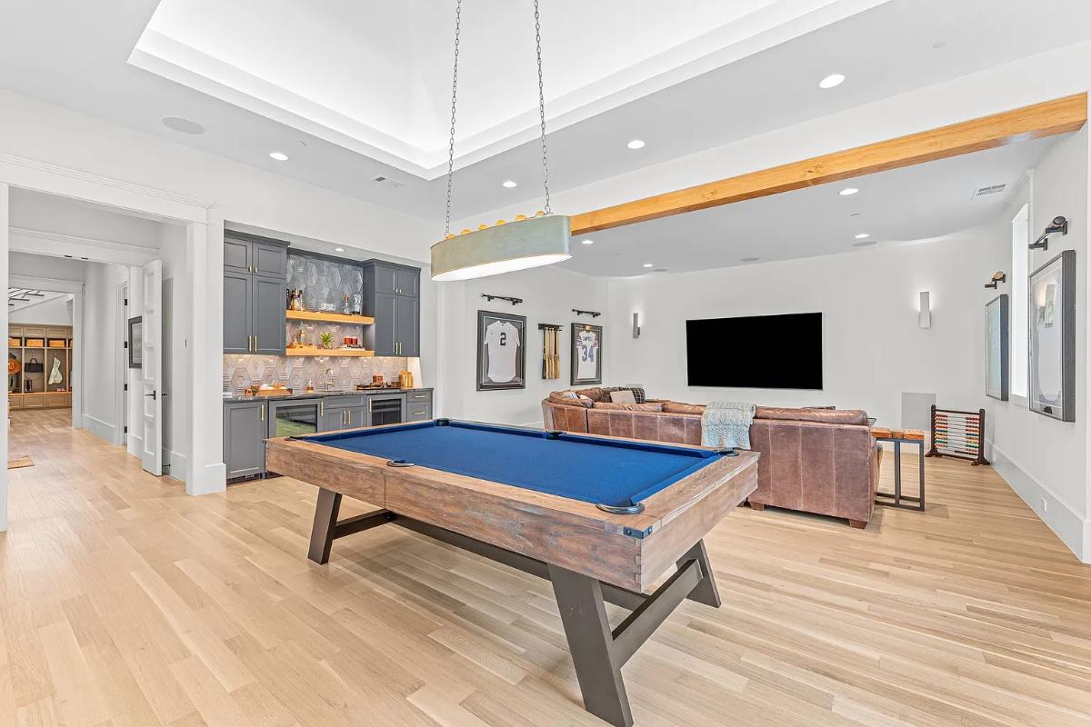 Recreation room with a billiards table, couches and a TV.