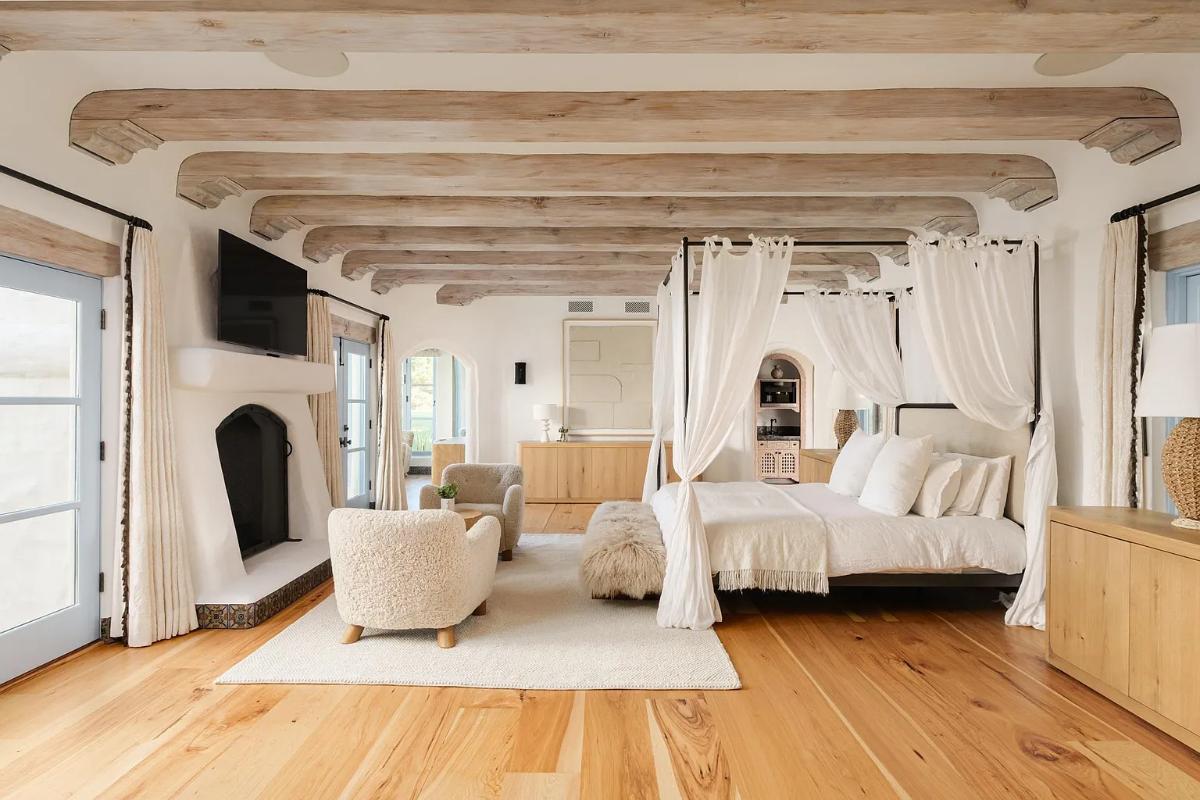 Bedroom with a fireplace and hardwood floors.