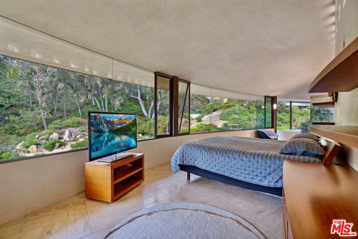 Bedroom with a large bed and glass walls.