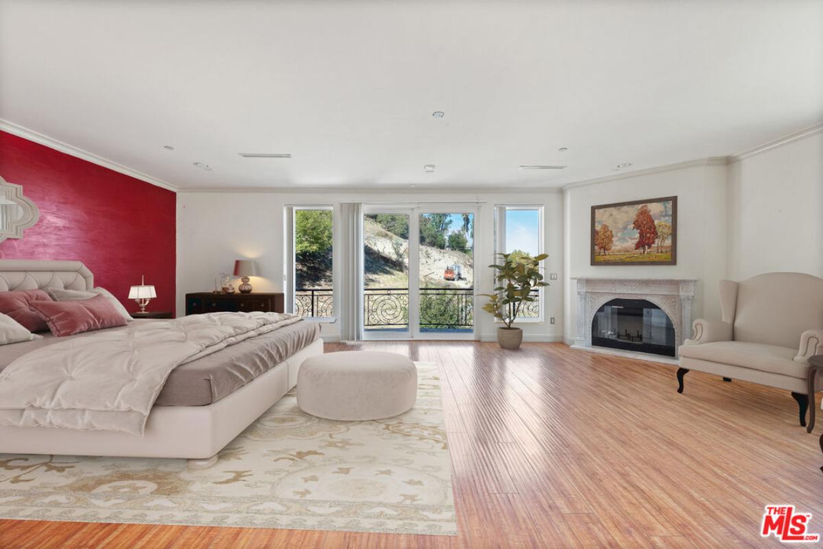 Bedroom with hardwood flooring and a fireplace.