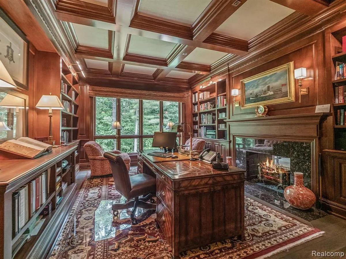 Home office with a fireplace and coffered ceilings.