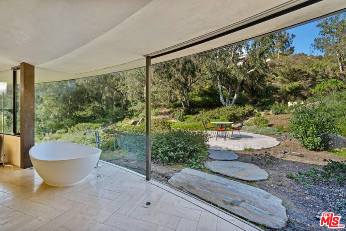 Bathroom with a soaking tub and glass walls.