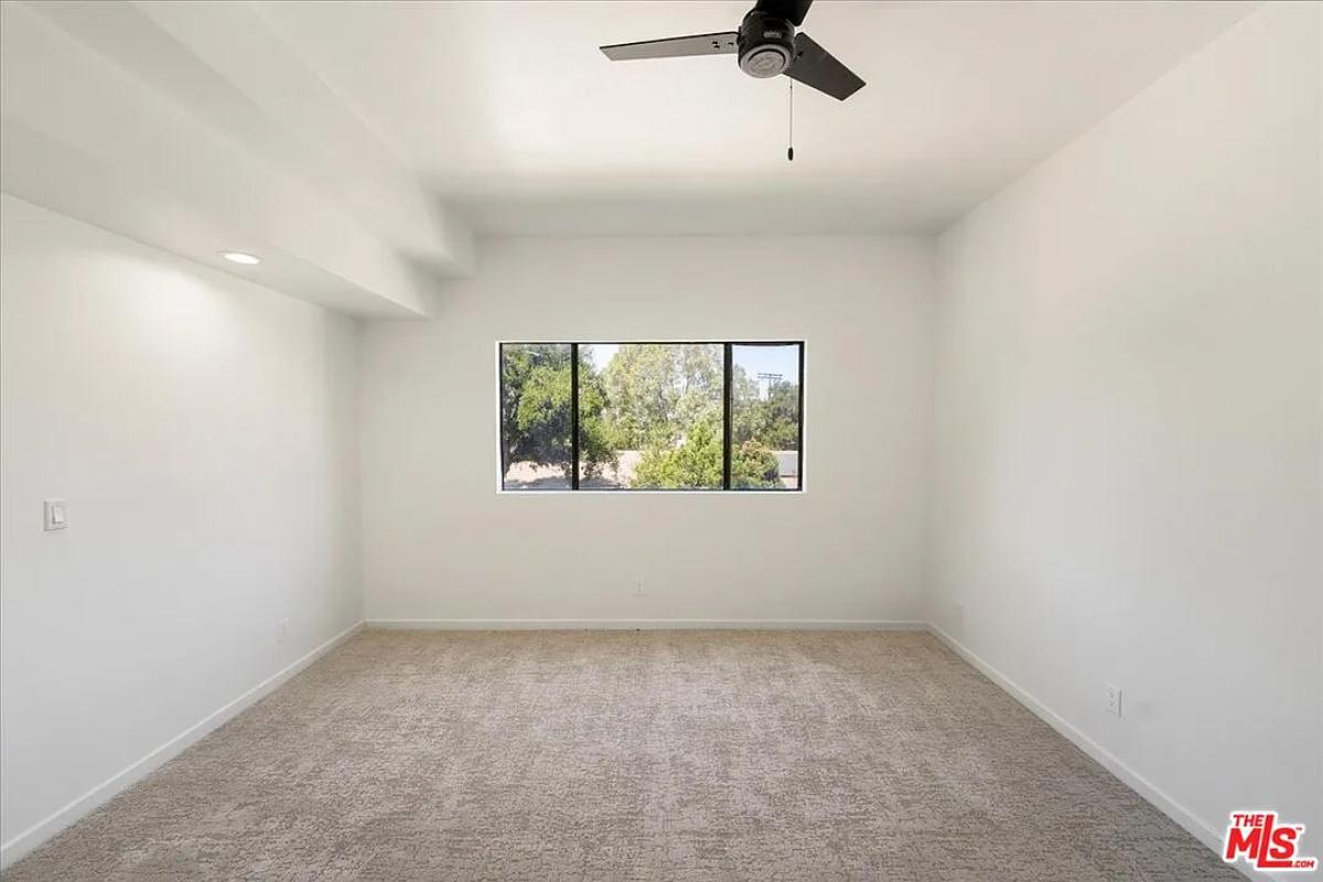Bedroom with glass windows and carpet flooring.