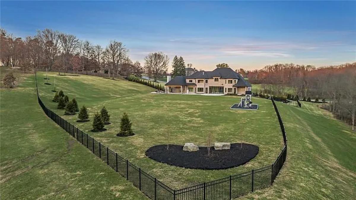 Rear view of the mansion with a large green lawn.