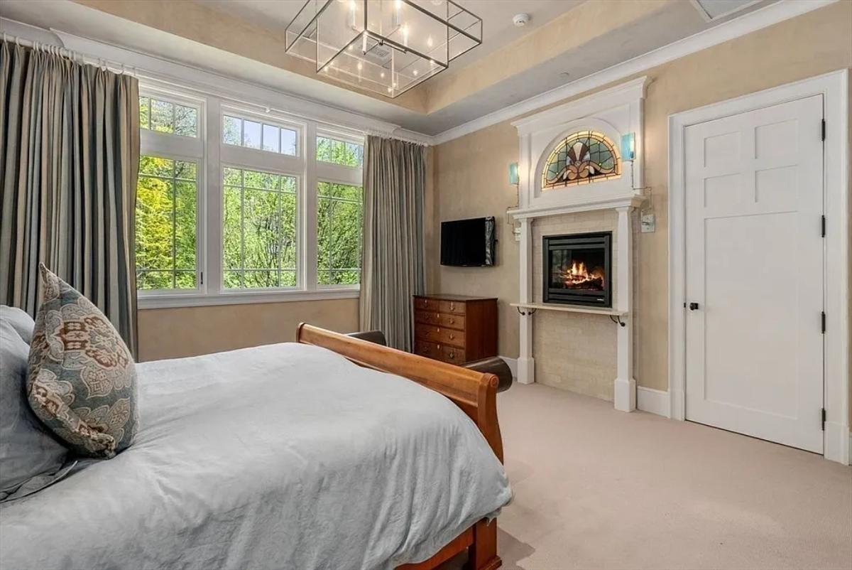 Bedroom with a fireplace and carpet flooring.
