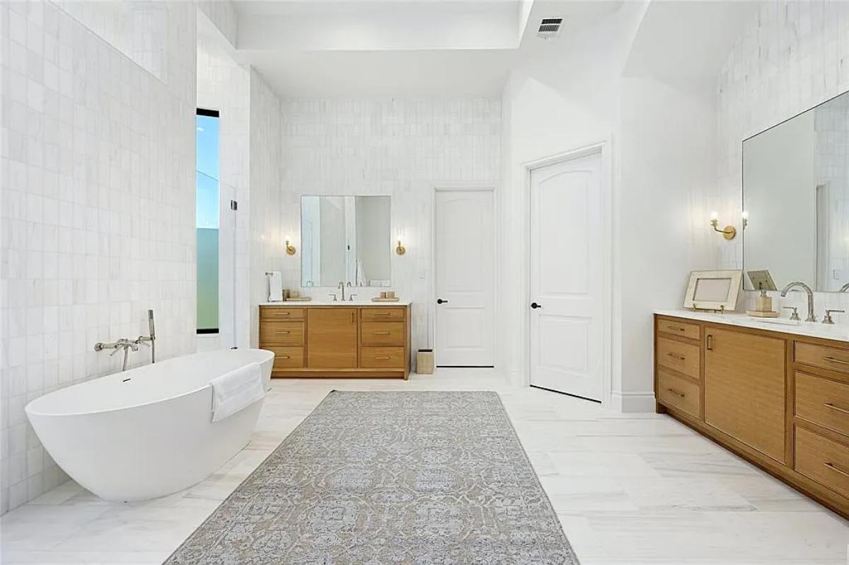Bathroom with custom-made vanities and a soaking tub.