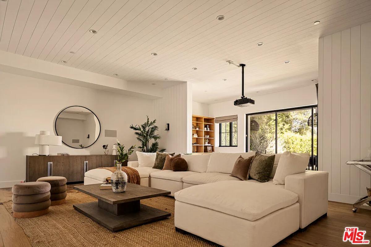 Living room with couches and hardwood floors.