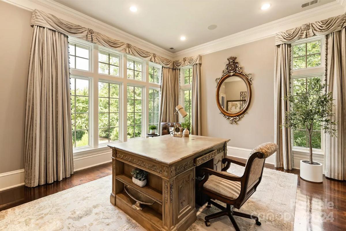 Home office with glass windows and hardwood floors.