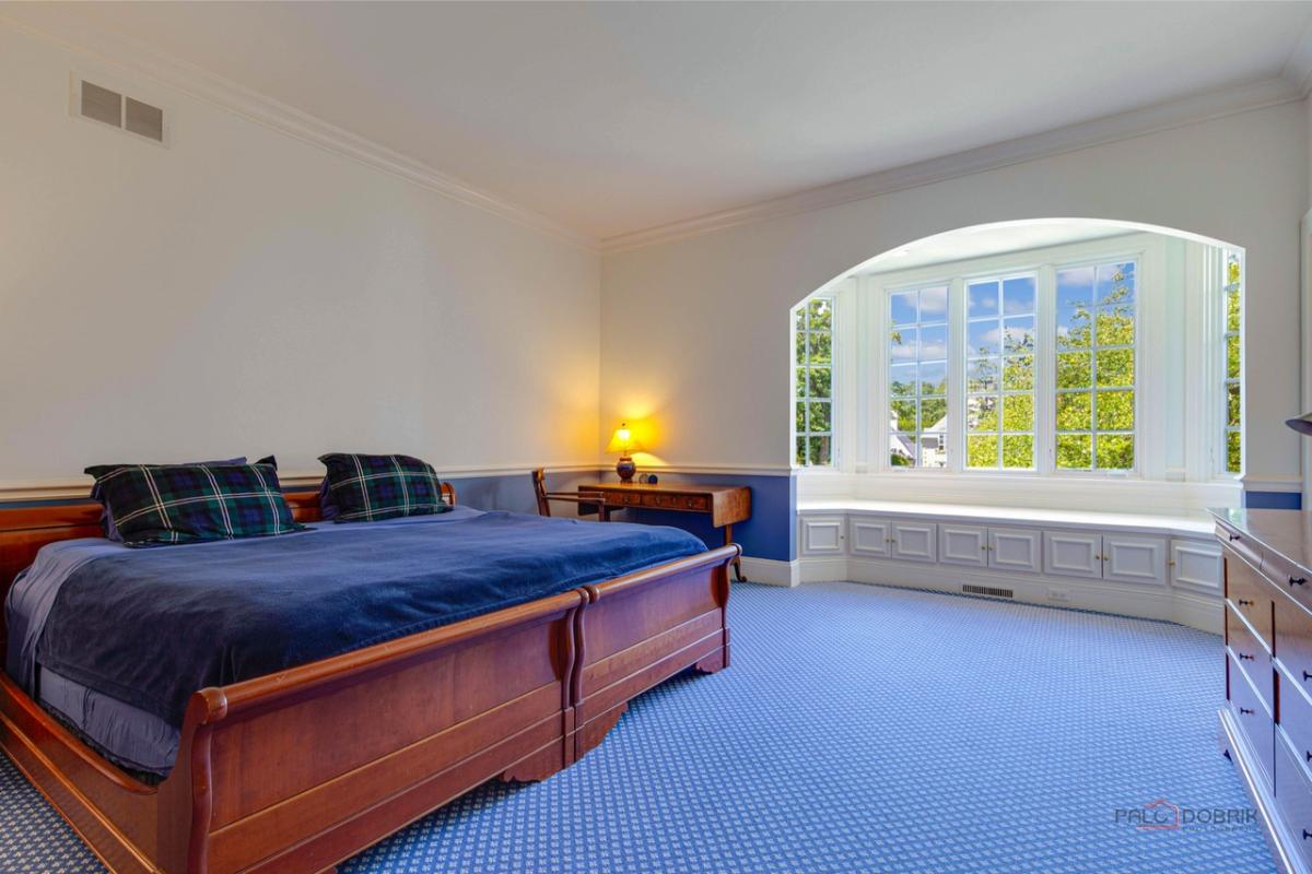 Bedroom with a large bed and carpet flooring.
