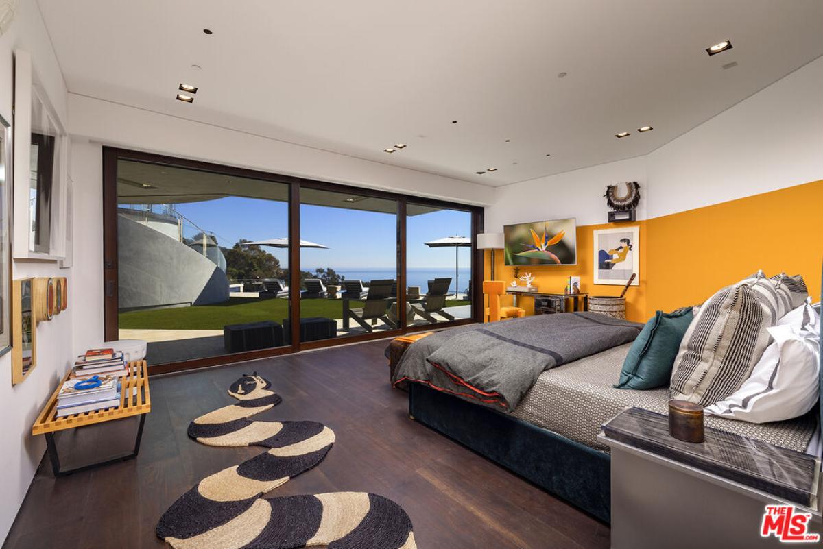 Bedroom with a large bed and sliding glass doors.