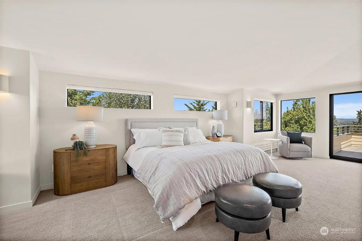 Bedroom with a large bed, sliding glass doors and carpet flooring.
