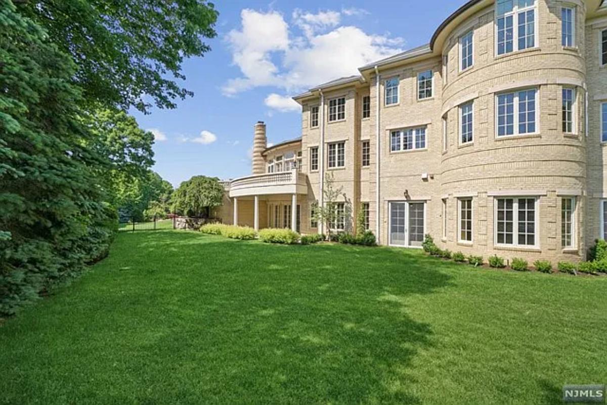 Exterior view of the mansion with a large green lawn.