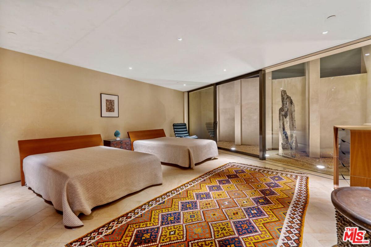 Bedroom with two beds and sliding glass doors.