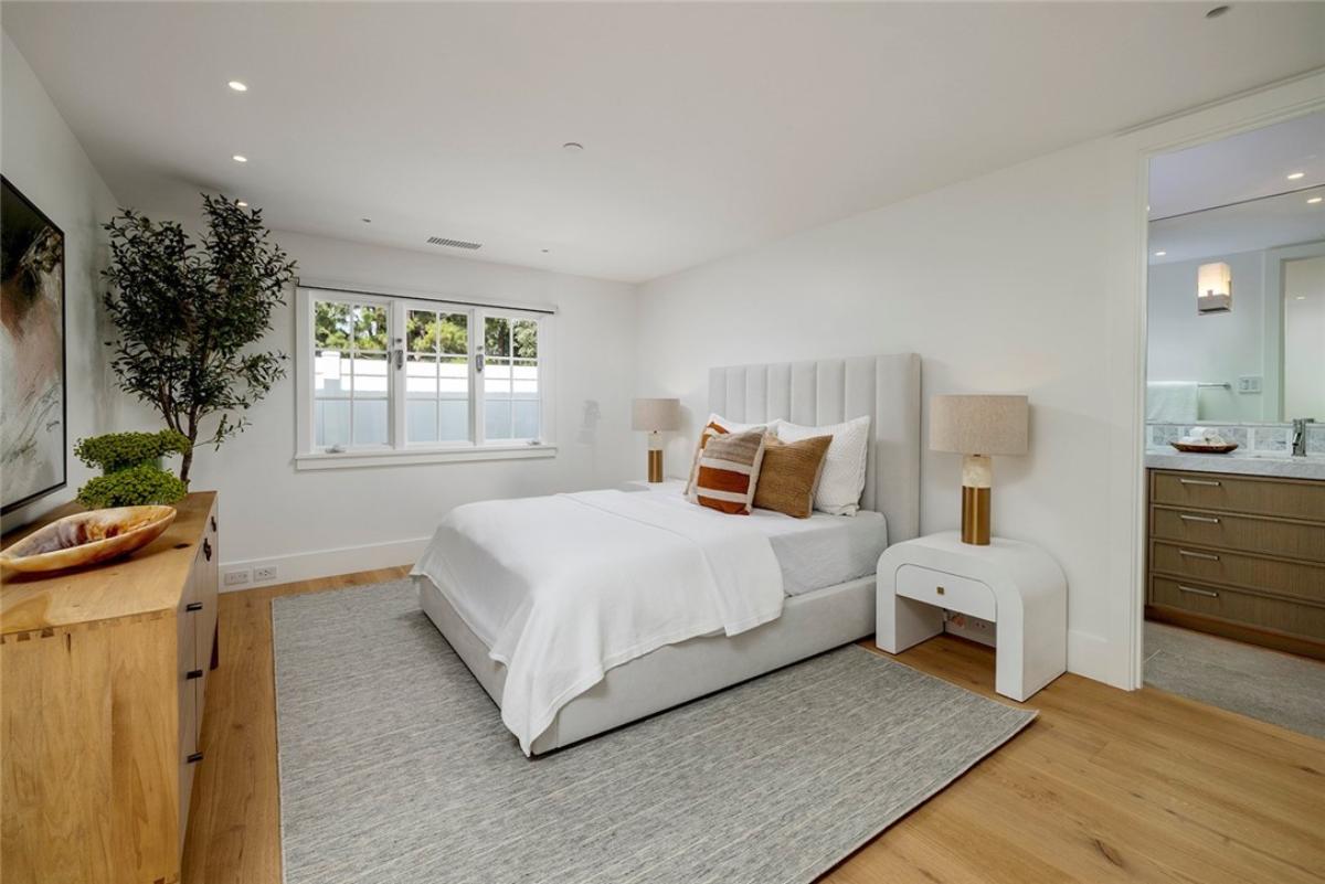 Bedroom with a large bed, a large rug and hardwood floors.
