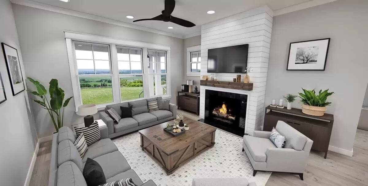 Great room with gray seats and a fireplace with a TV on top.